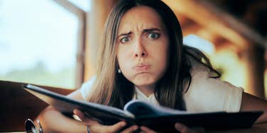 surprised, frustrated woman looking at menu