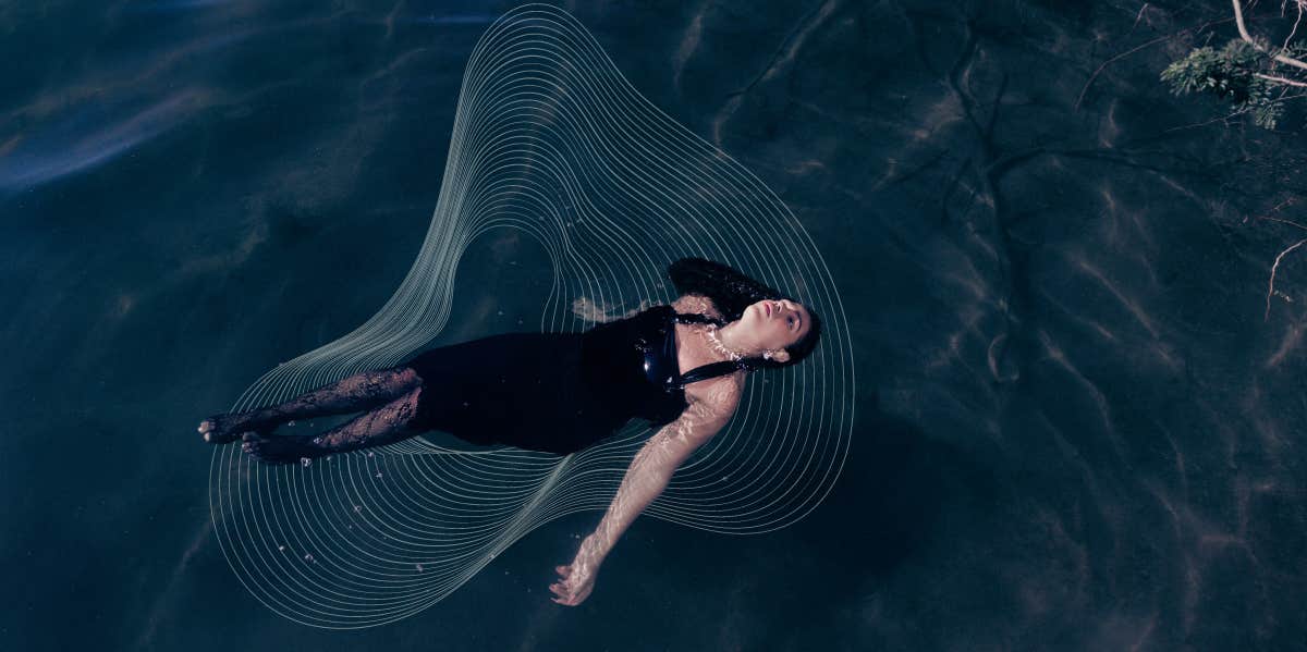 Fully clothed woman floating in water