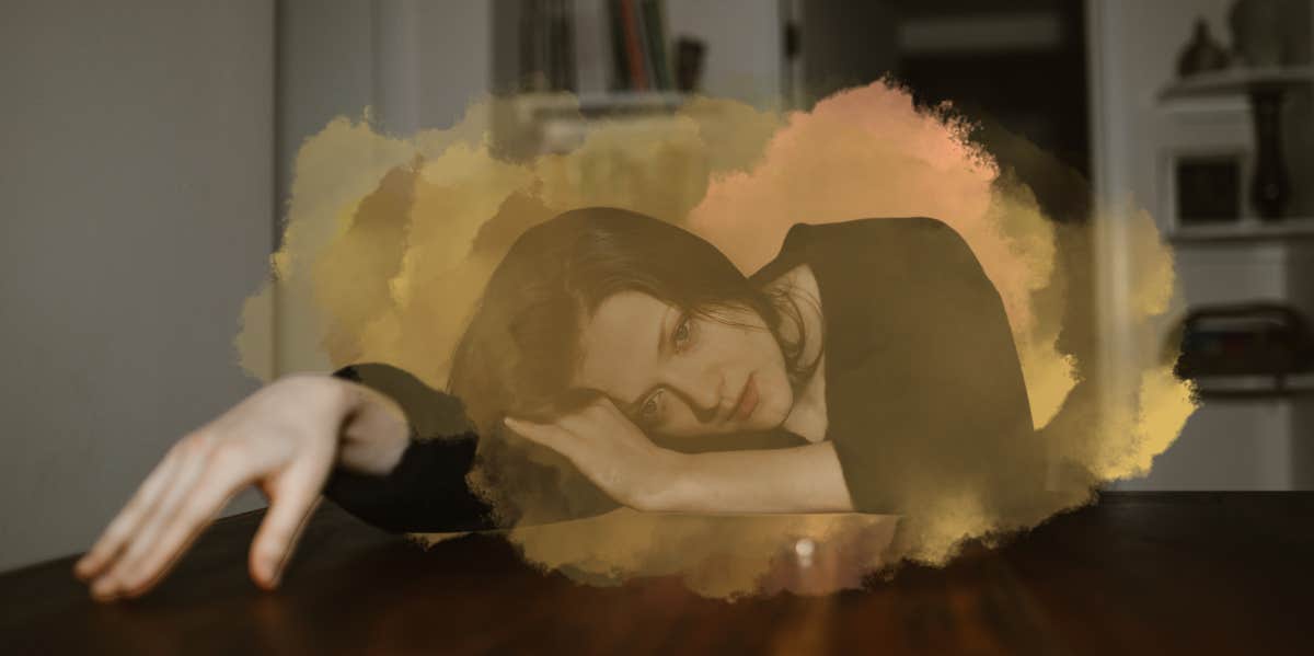 Woman laying on desk consumed by her thoughts, post breakup