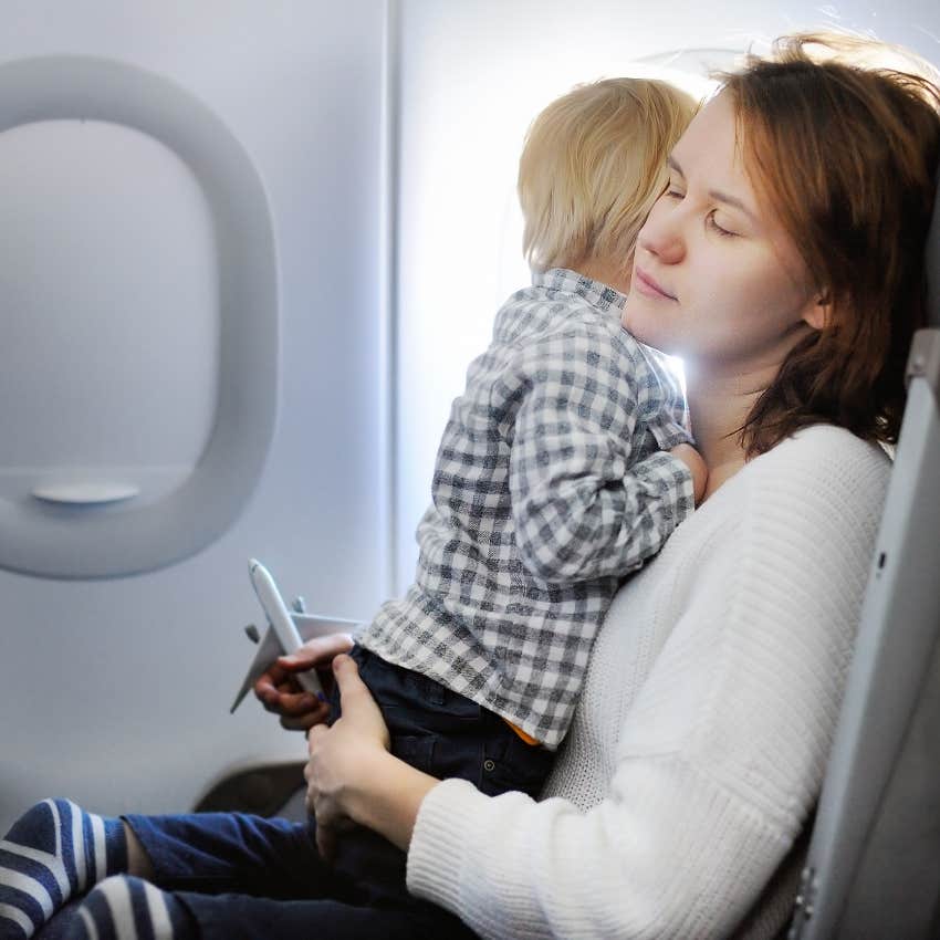 stressed mom holding child on plane