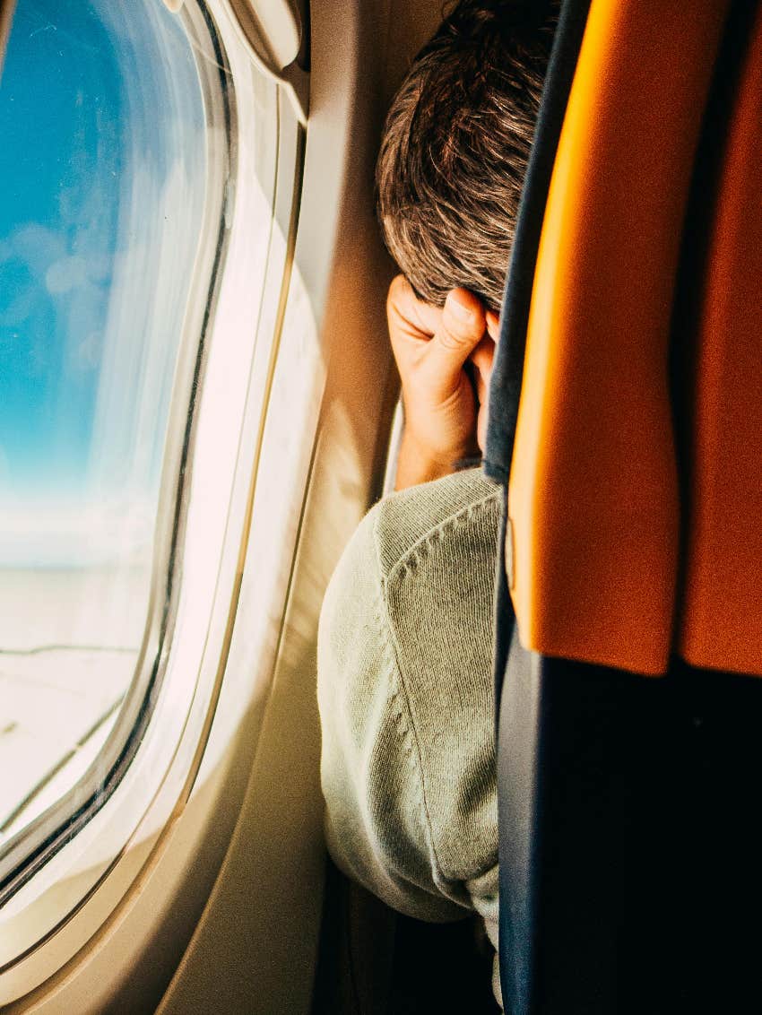 man on airplane by window 
