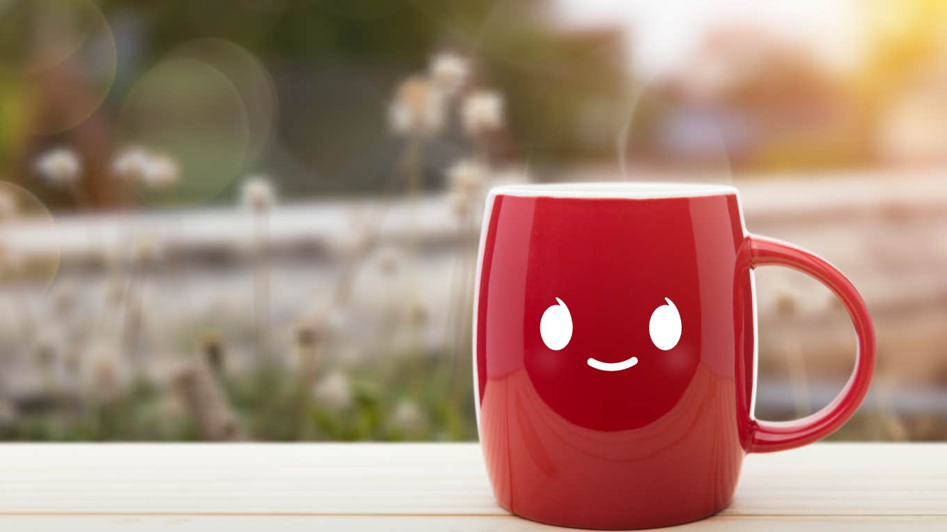 a smiling face on a red mug