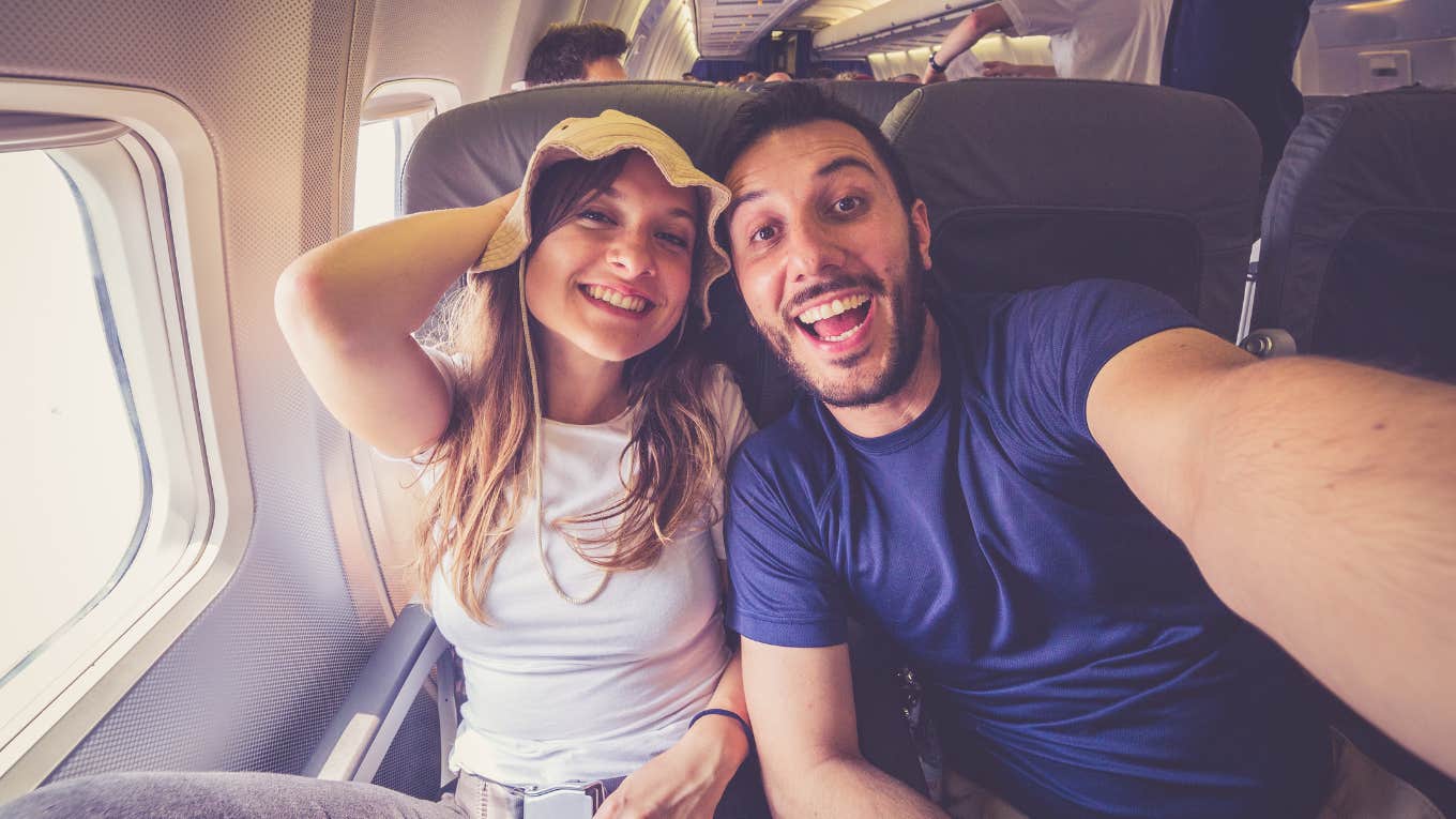 couple taking a selfie on the airplane during flight
