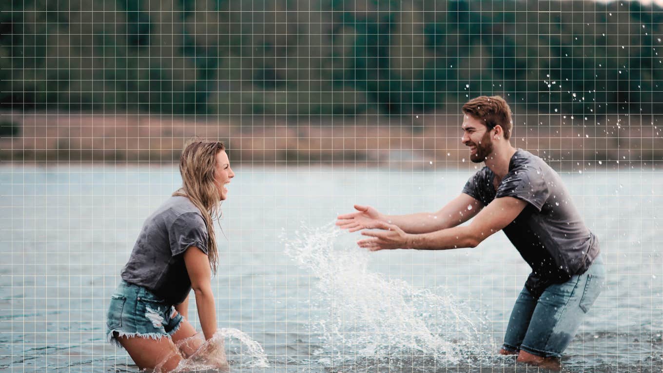 Couple being playful at the lake, splashing each other
