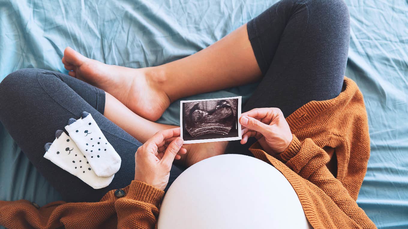 pregnant woman holding baby sonogram photo