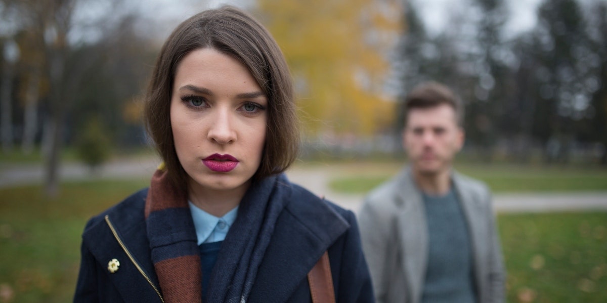 upset looking woman with man behind her