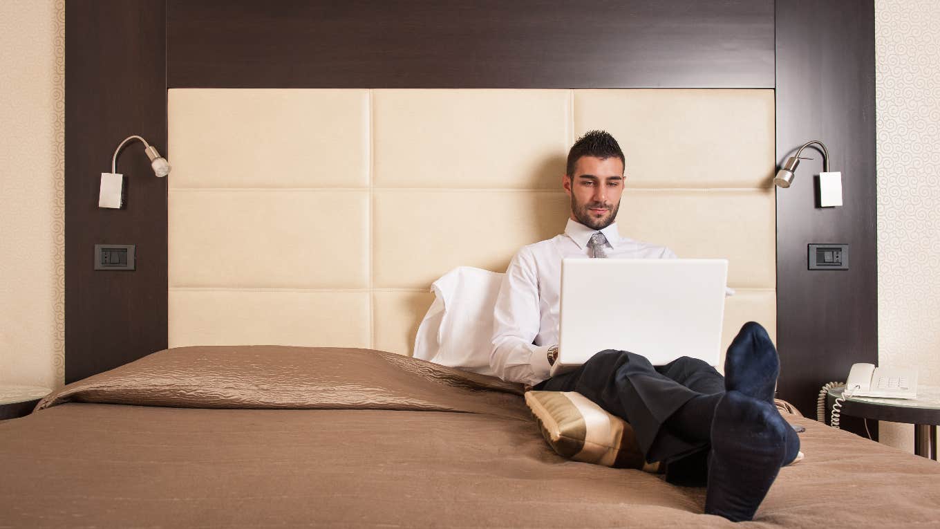 employee on hotel bed for work trip