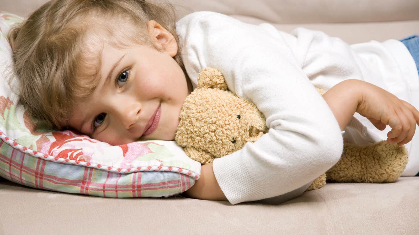 little girl hugging stuffed teddy bear