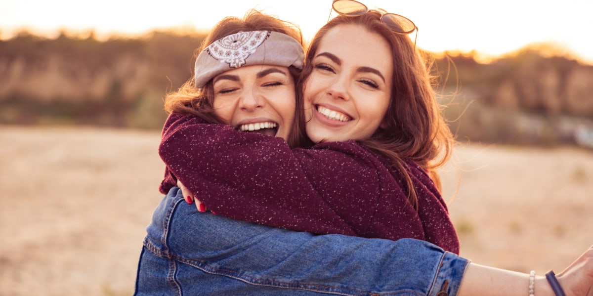 two friends smiling hugging