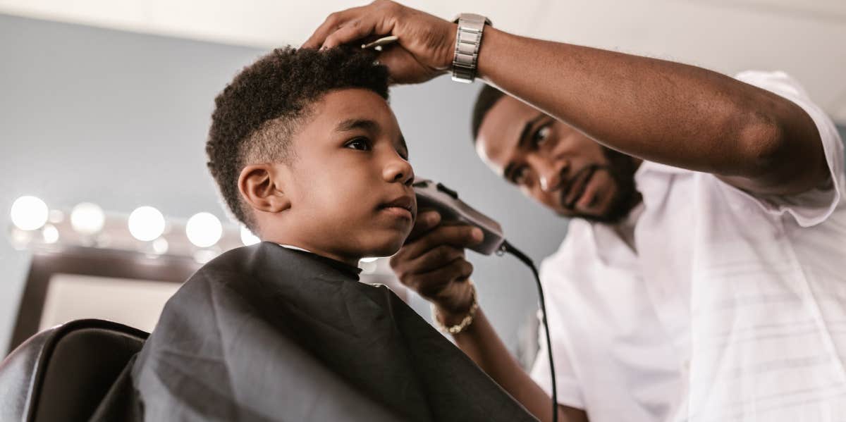 barber cutting little boy's hair