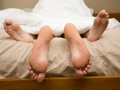 feet of couple in bed