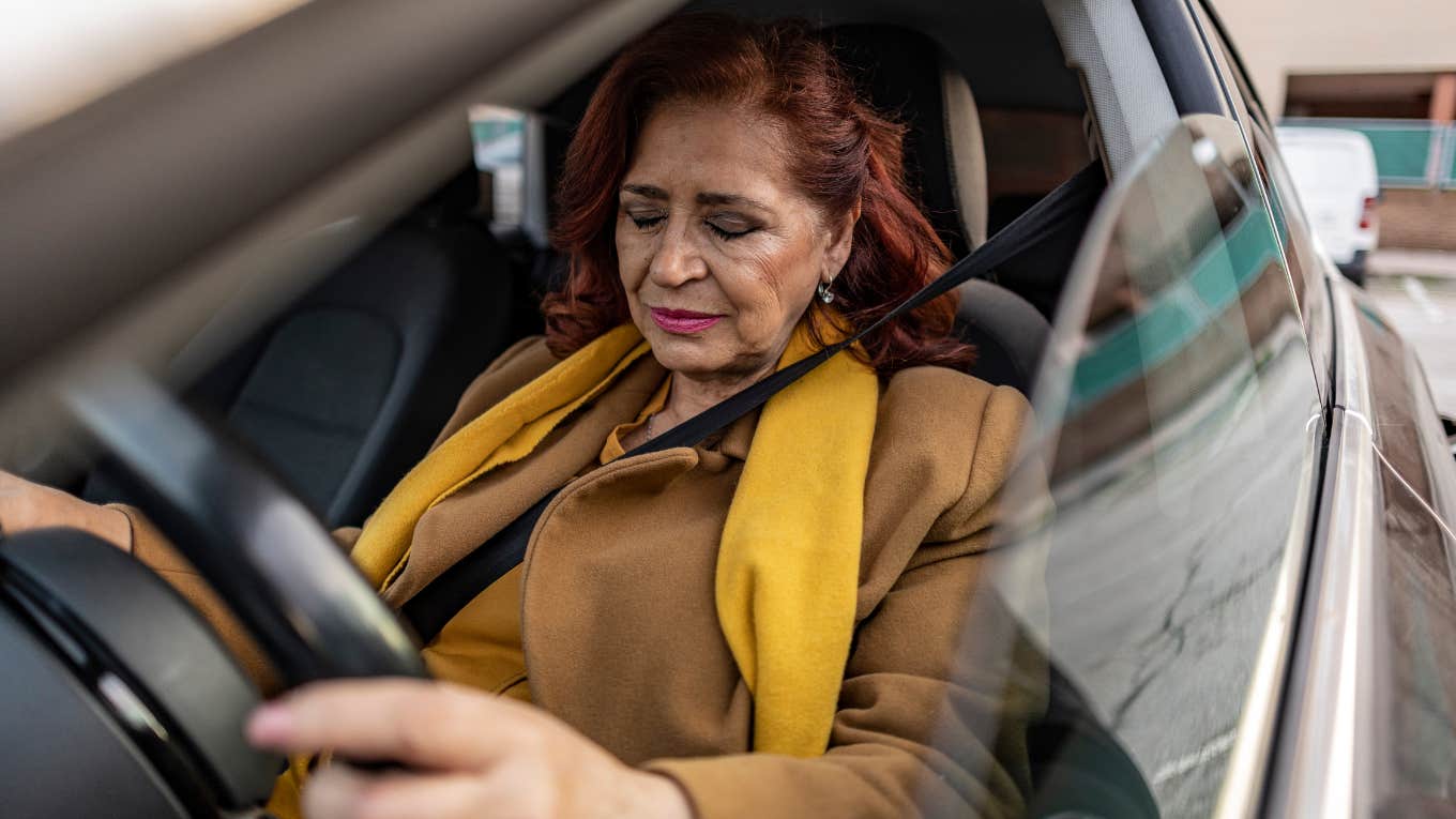 Woman looking upset while sitting in her car. 