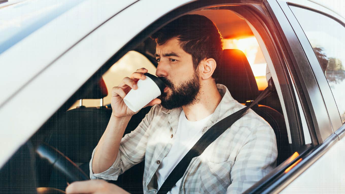 man in car drinking coffee without a care 