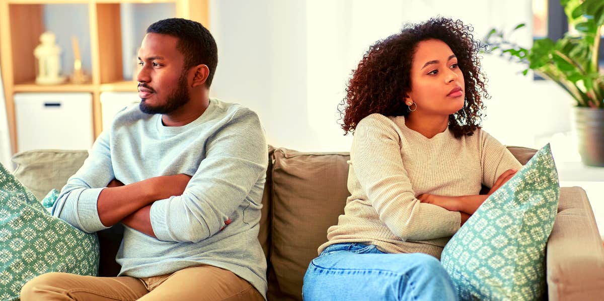 unhappy couple sitting on couch looking away from each other