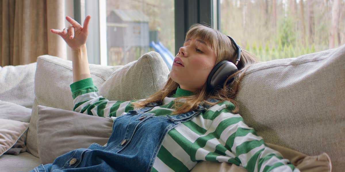 woman listening to music on a couch