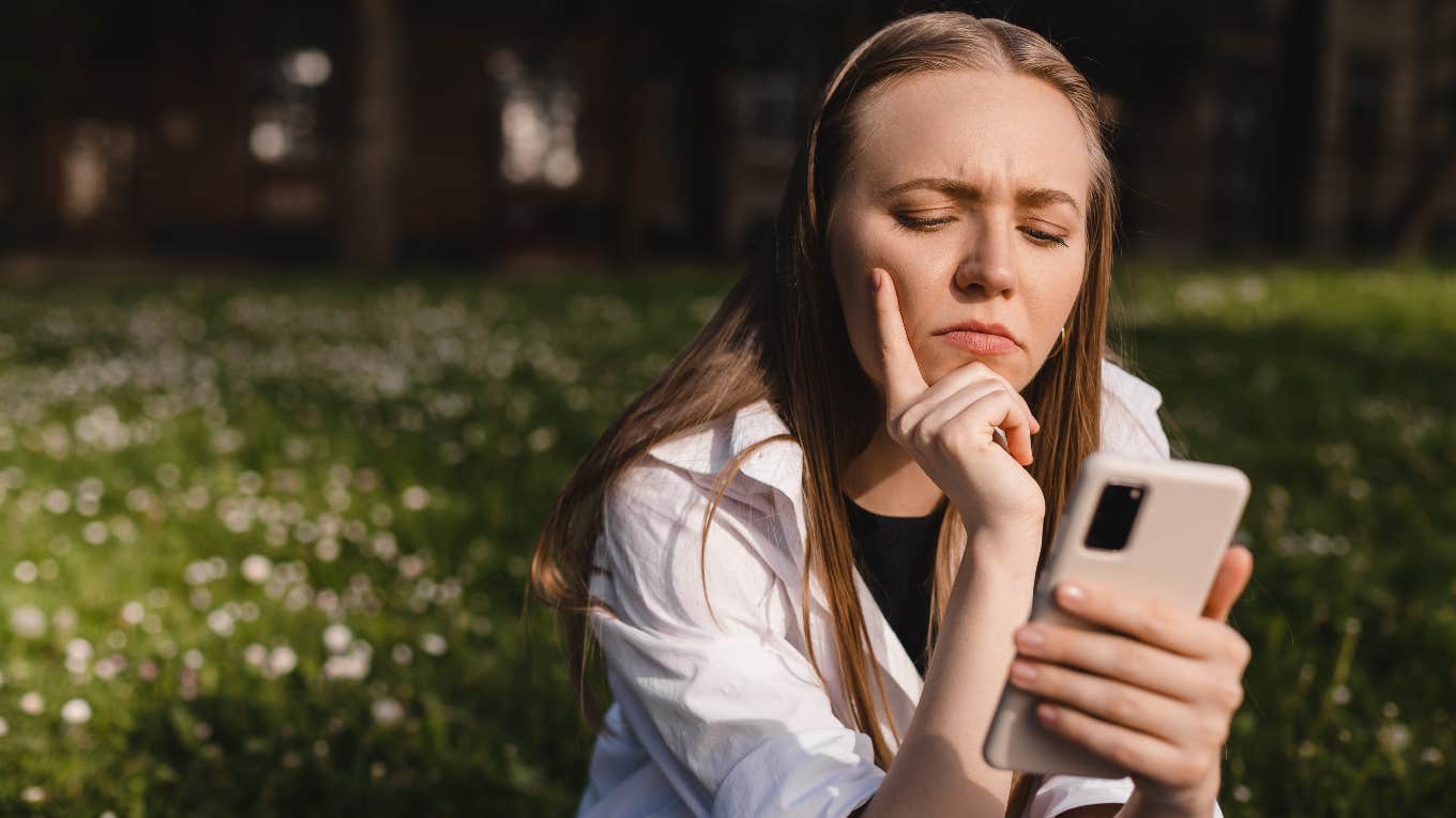 woman with upset face reading phone