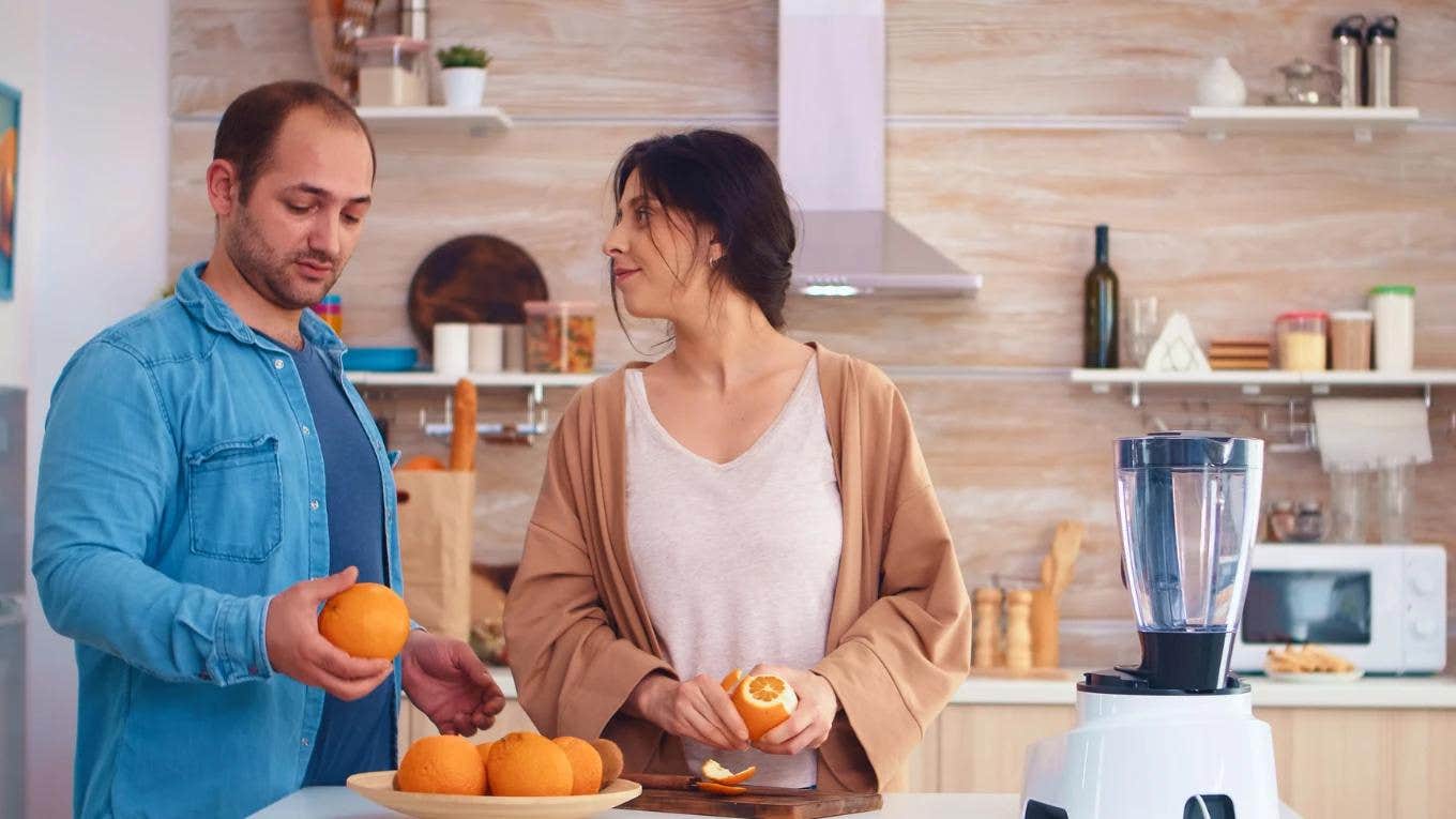 woman peeling an orange for her partner