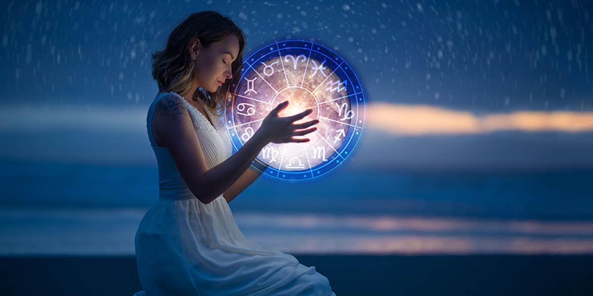 woman holding zodiac wheel