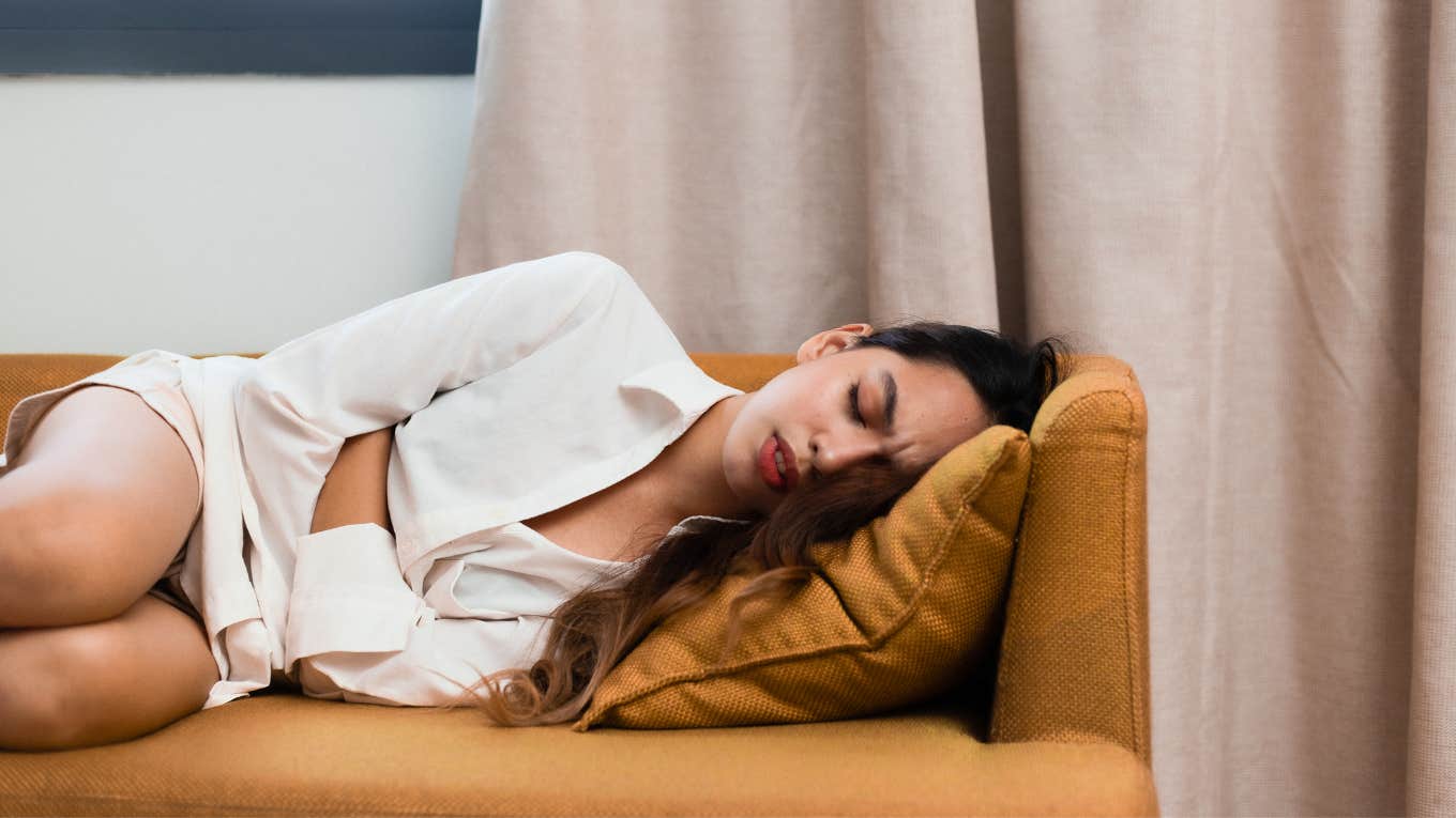 woman laying on couch with period cramps