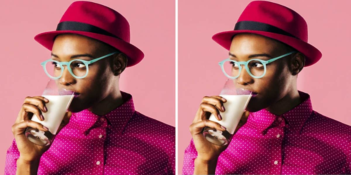 A fashionable women sips a glass of milk knowingly