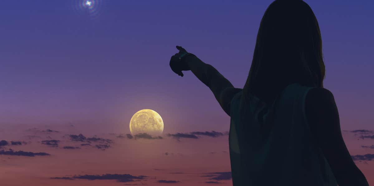 woman pointing toward the moon