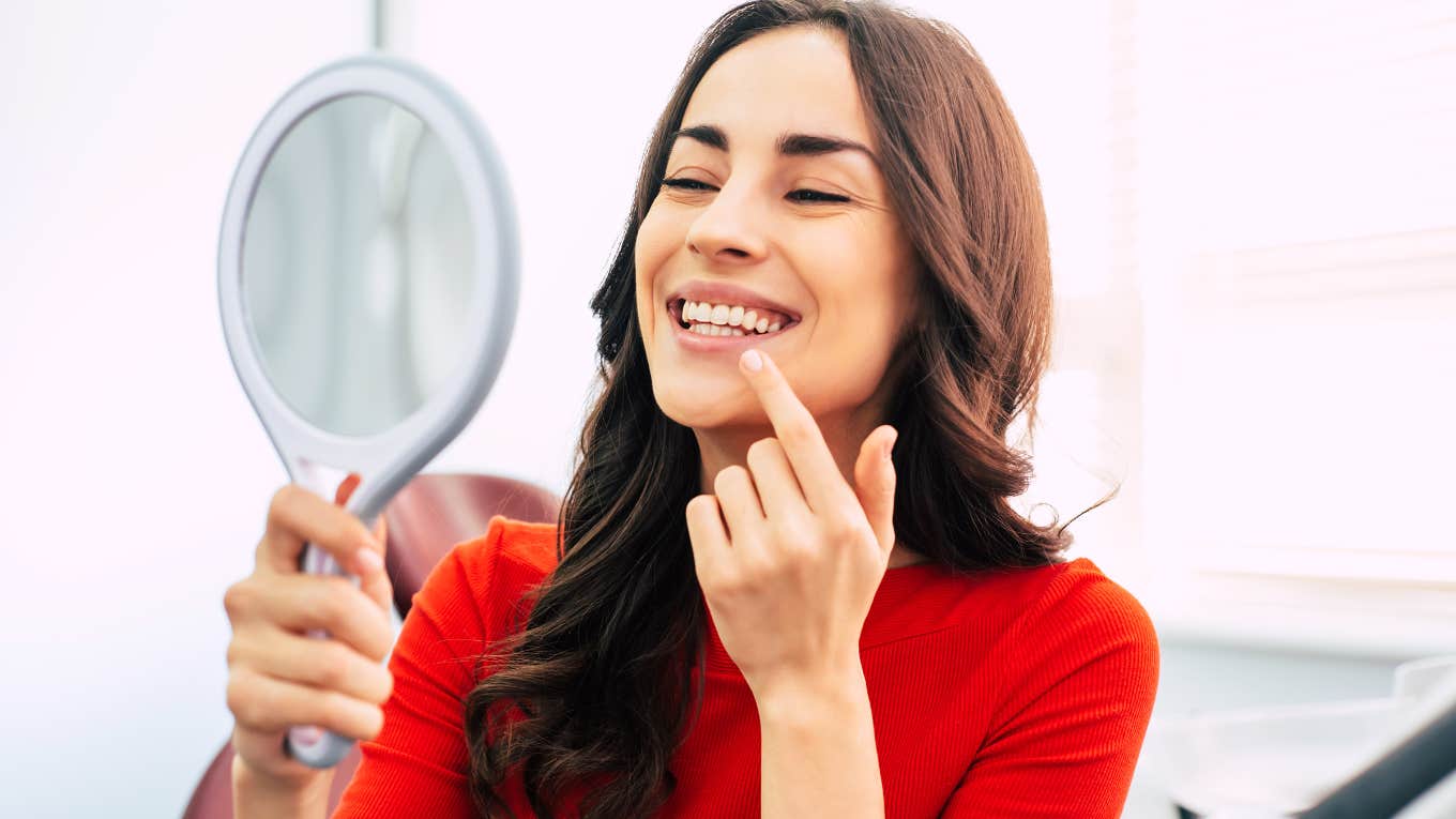 woman checking out her teeth in a mirror