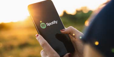 woman holding phone with Spotify open