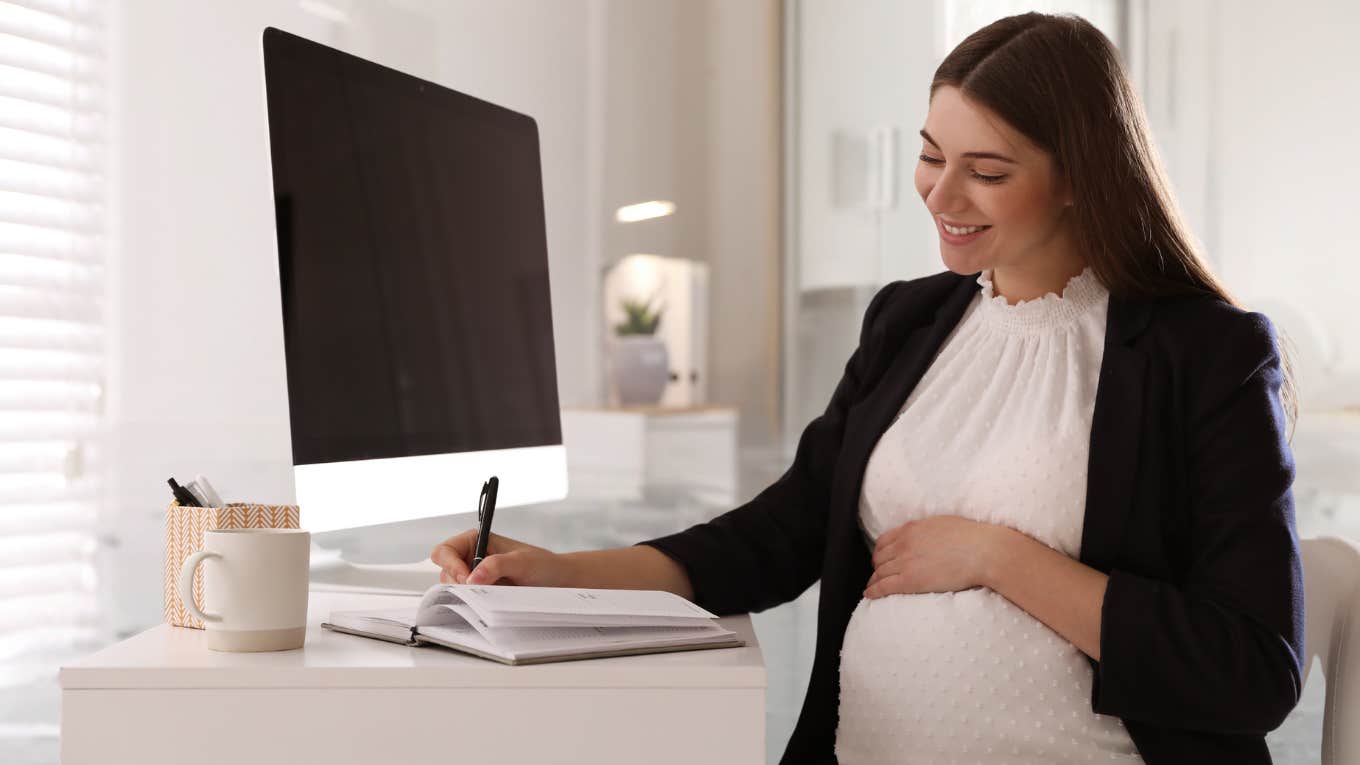 Pregnant woman working at a desk. 