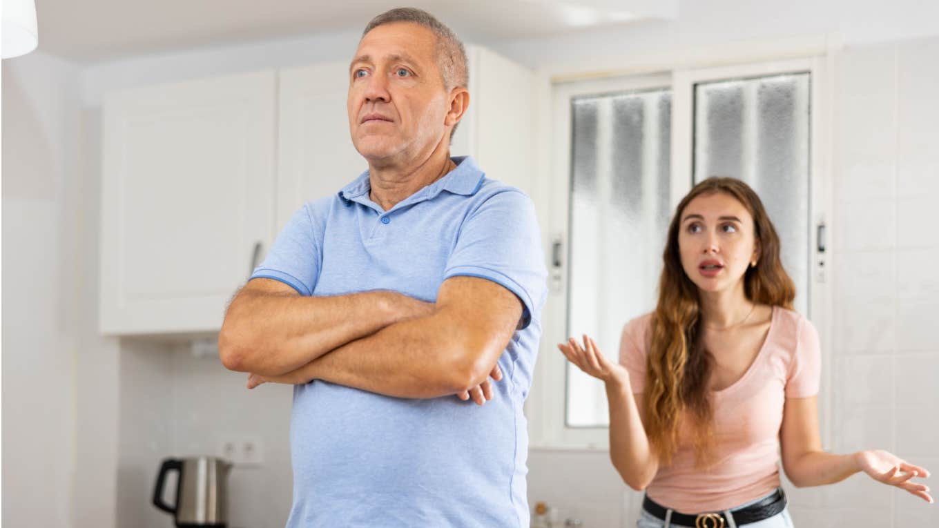 adult daughter argues with dad in kitchen of house