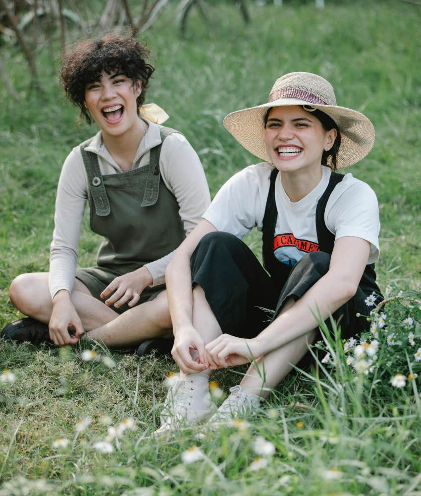 two young people sitting in a field