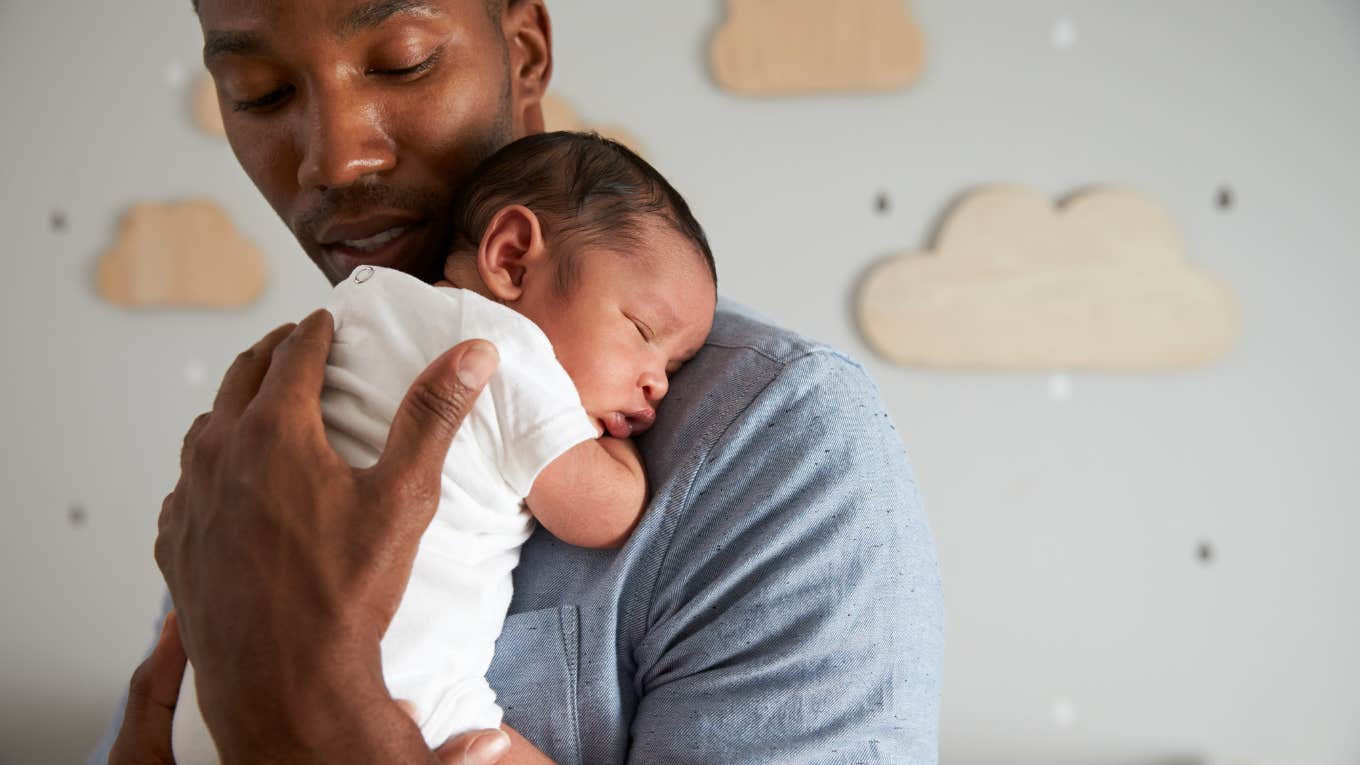 Father Holding Newborn Baby Son In Nursery