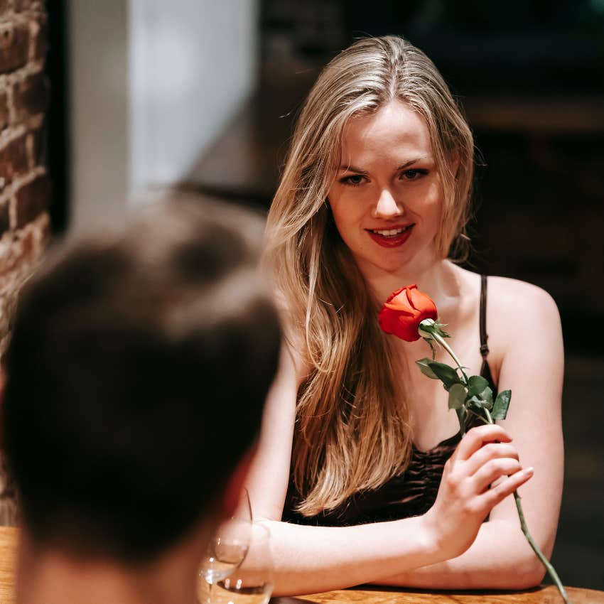 Woman holding red rose during first date