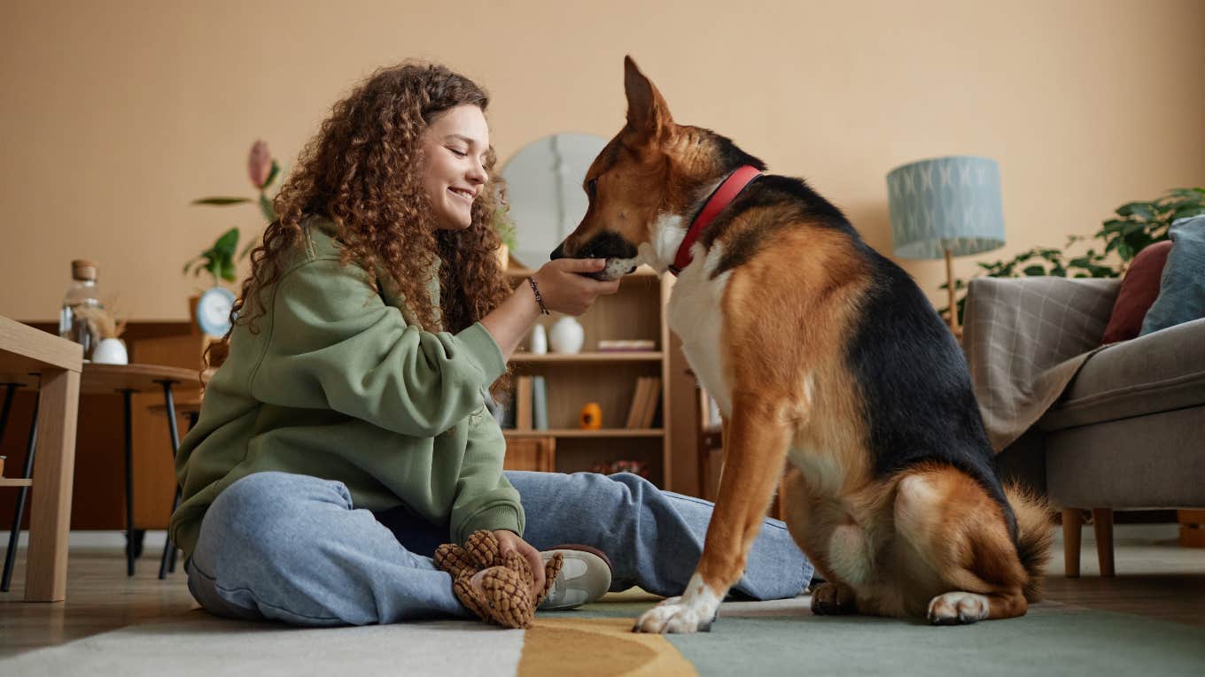 Woman training her dog not to bark with treats