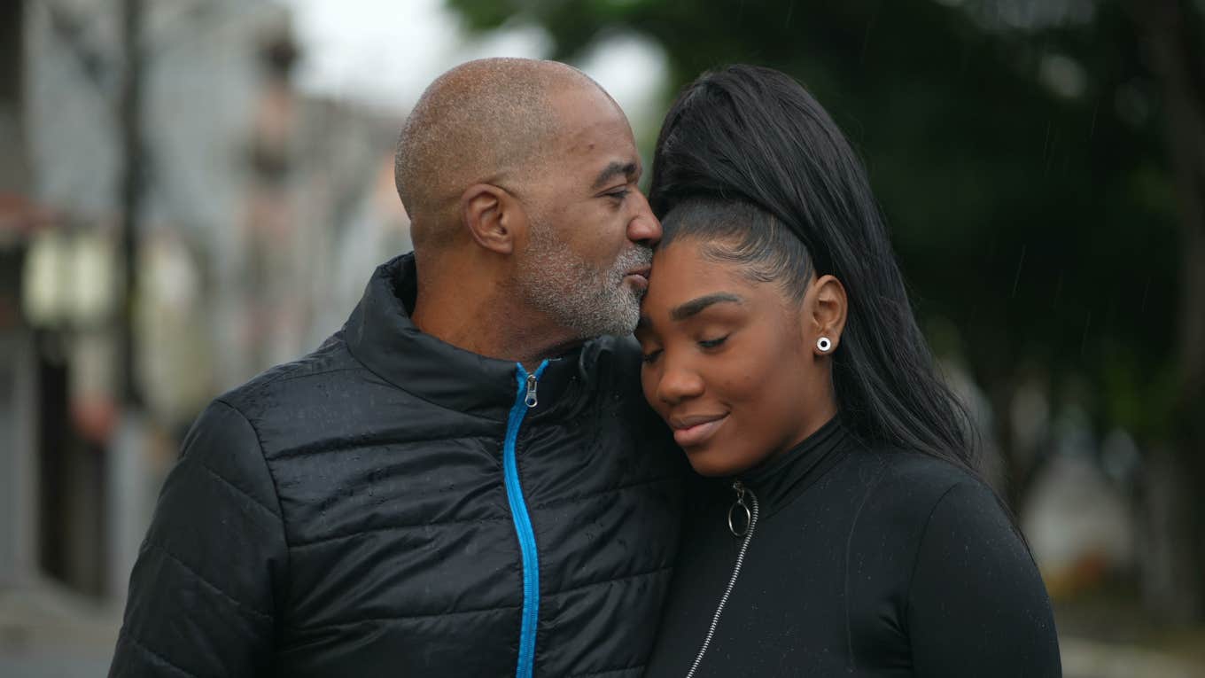 dad kissing teen daughter on forehead