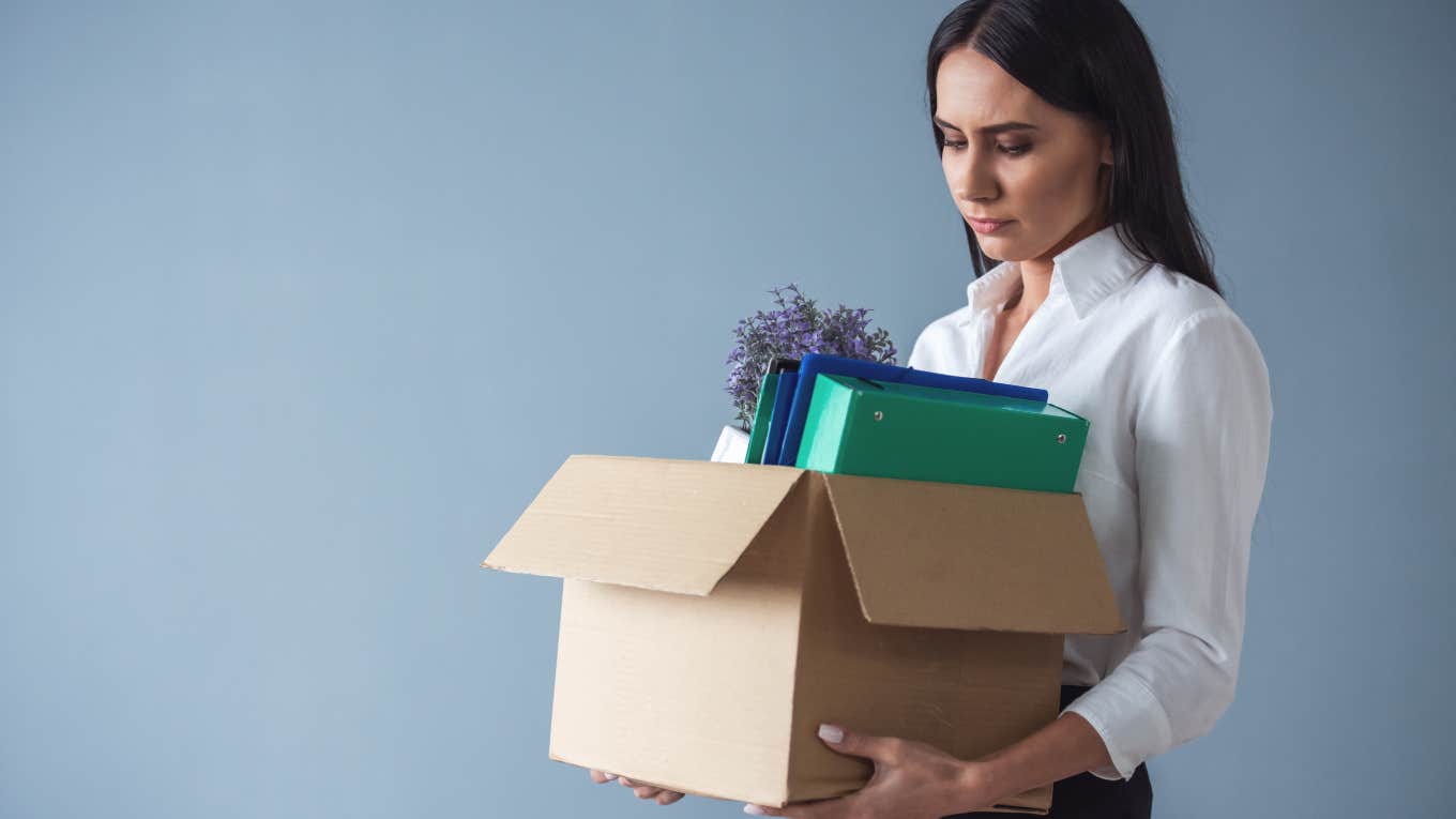 businesswoman carrying out a box of her things after getting fired