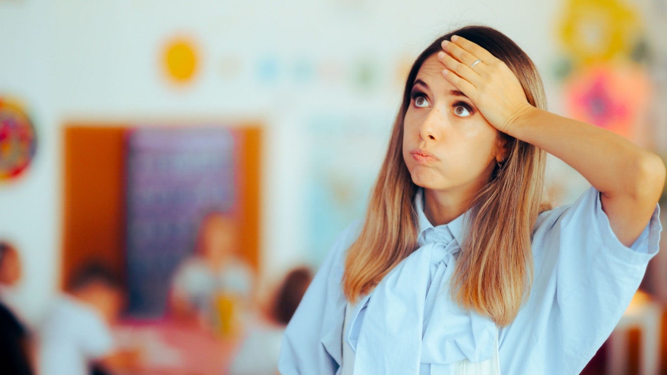 Upset teacher blowing out air in classroom