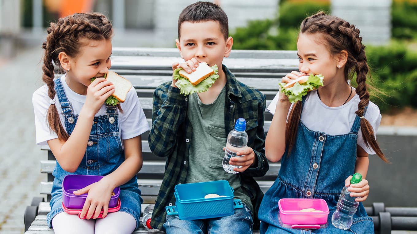 Elementary kids eating school lunches together. 