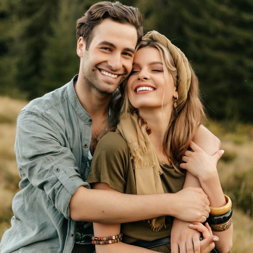 young couple hugging and smiling together on nature background