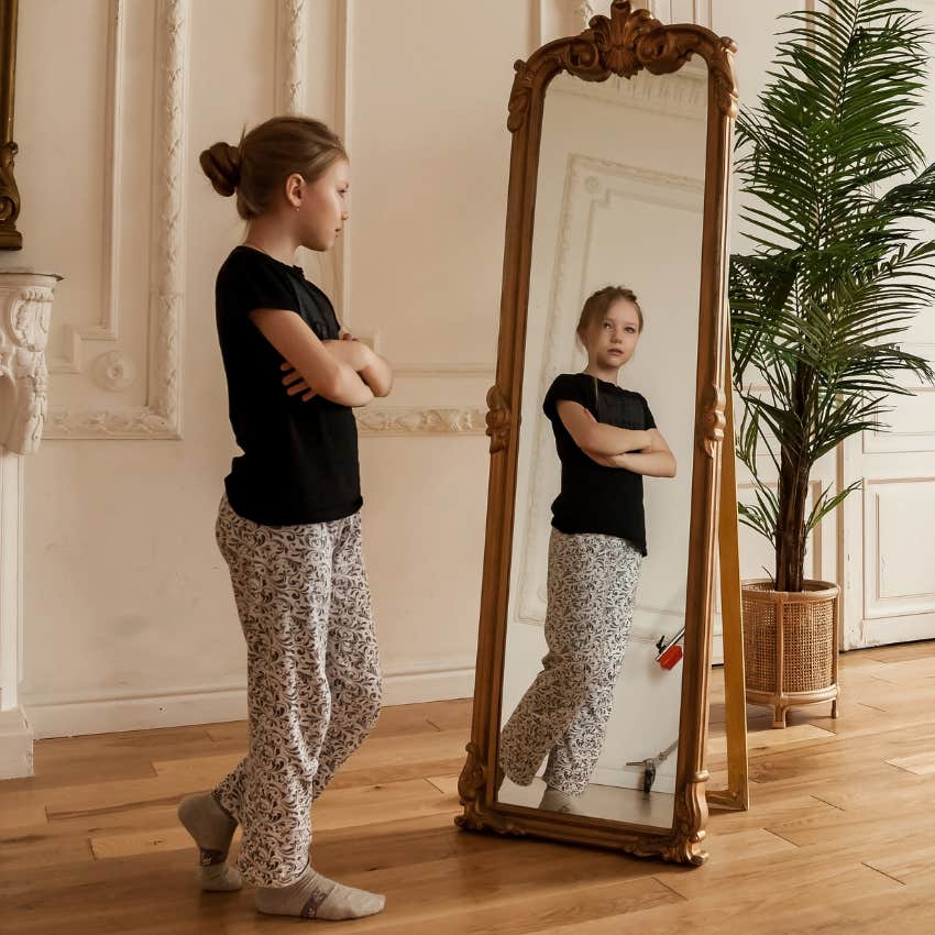 Little girl looking at herself in a mirror. 