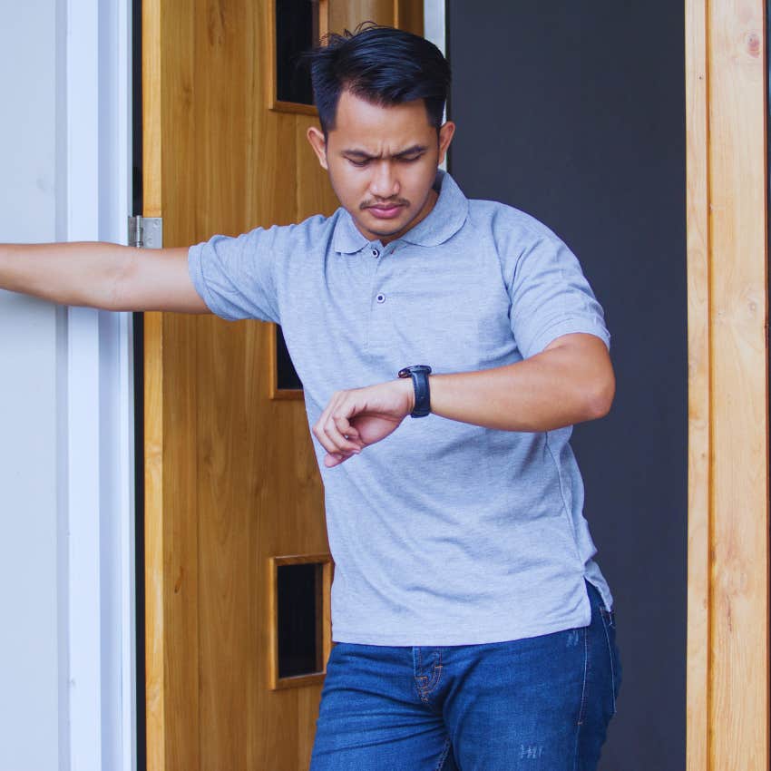 man looking at watch waiting by front door