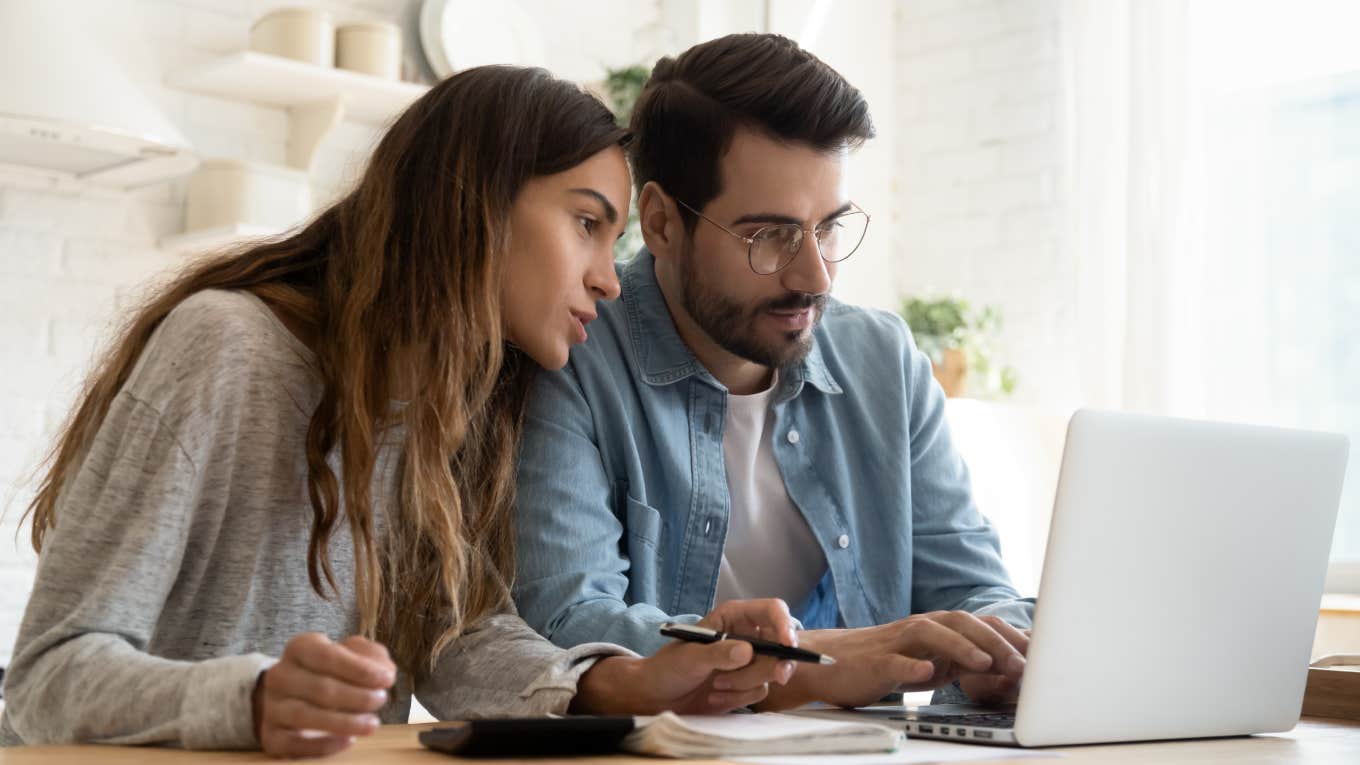 young couple calculating bills and looking at laptop screen