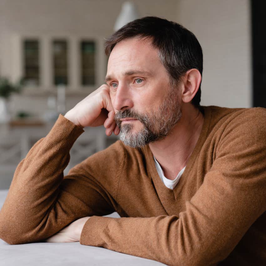 sad middle-aged man sitting with hand on the side of his face