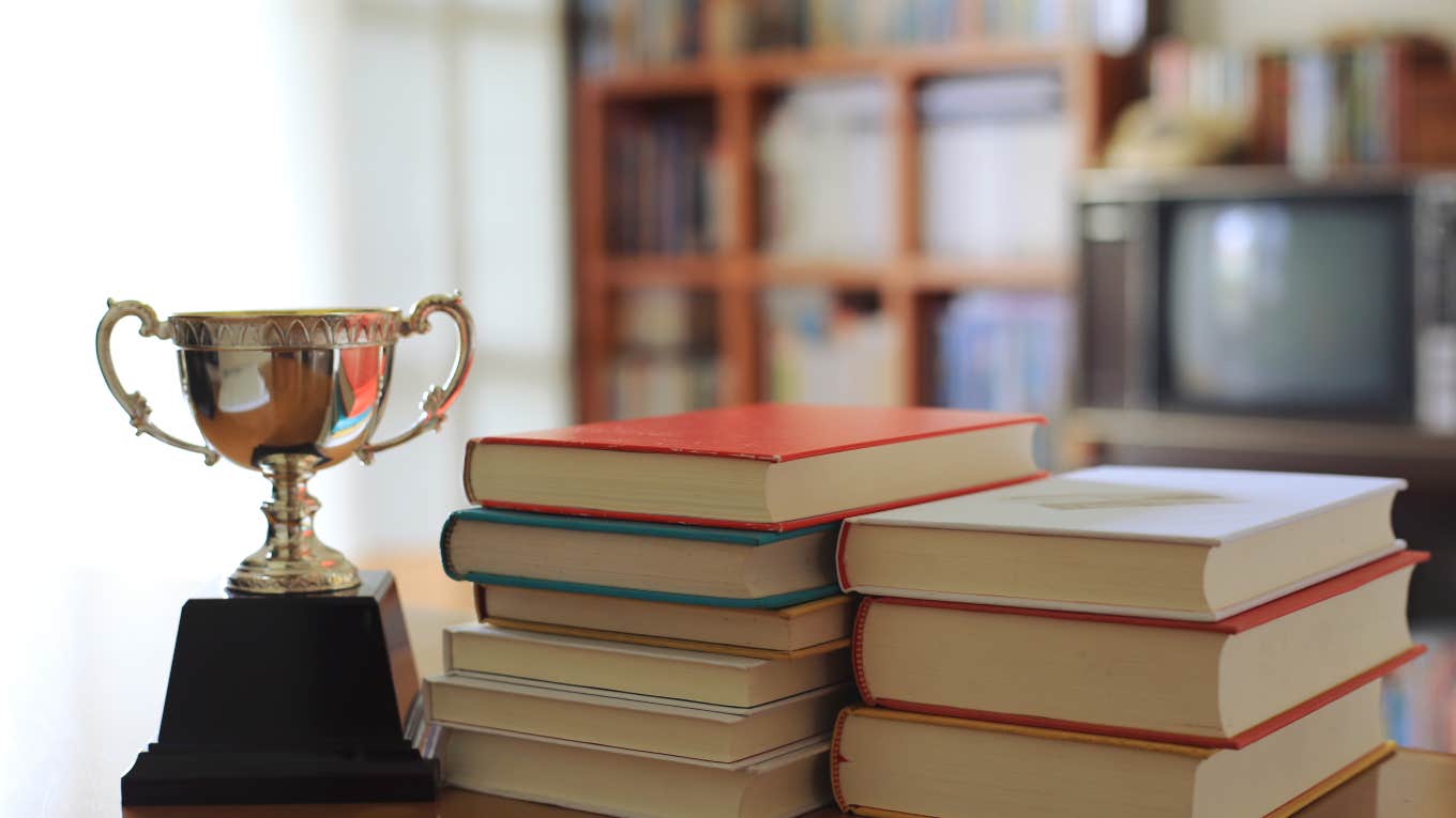 trophy next to two stacks of books