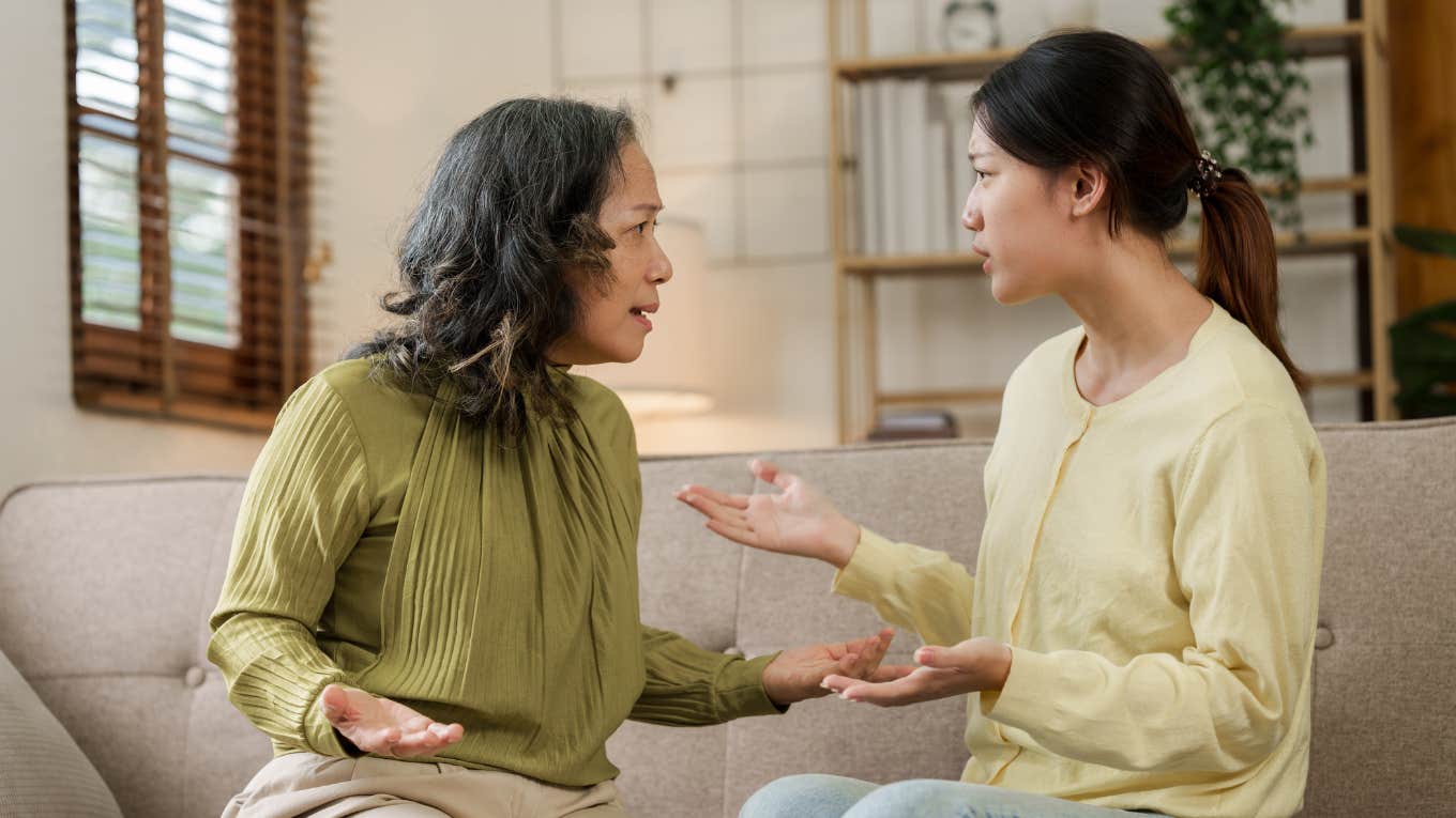 mom and adult daughter have fight at home while sitting on sofa.