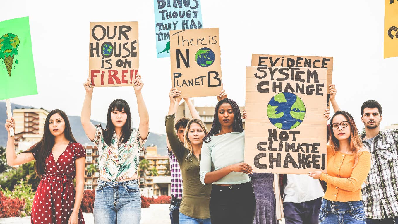 Young climate activists holding signs