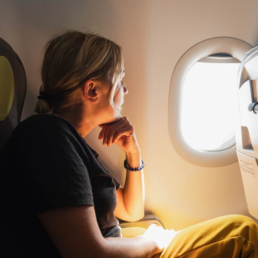 Girl sitting in airplane looking out window 
