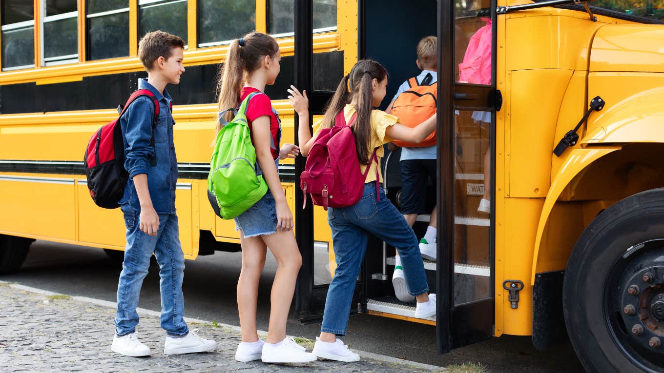 young students getting on school bus