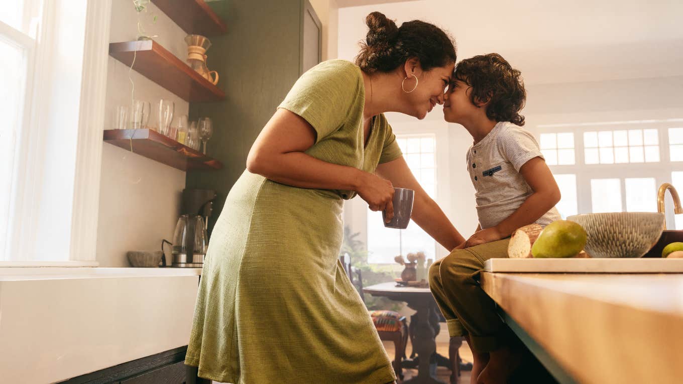 Affectionate mother touching noses with her young son in the kitchen