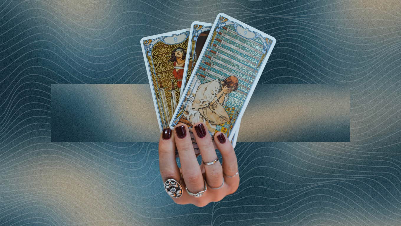 hand holding tarot cards for may 25 daily reading