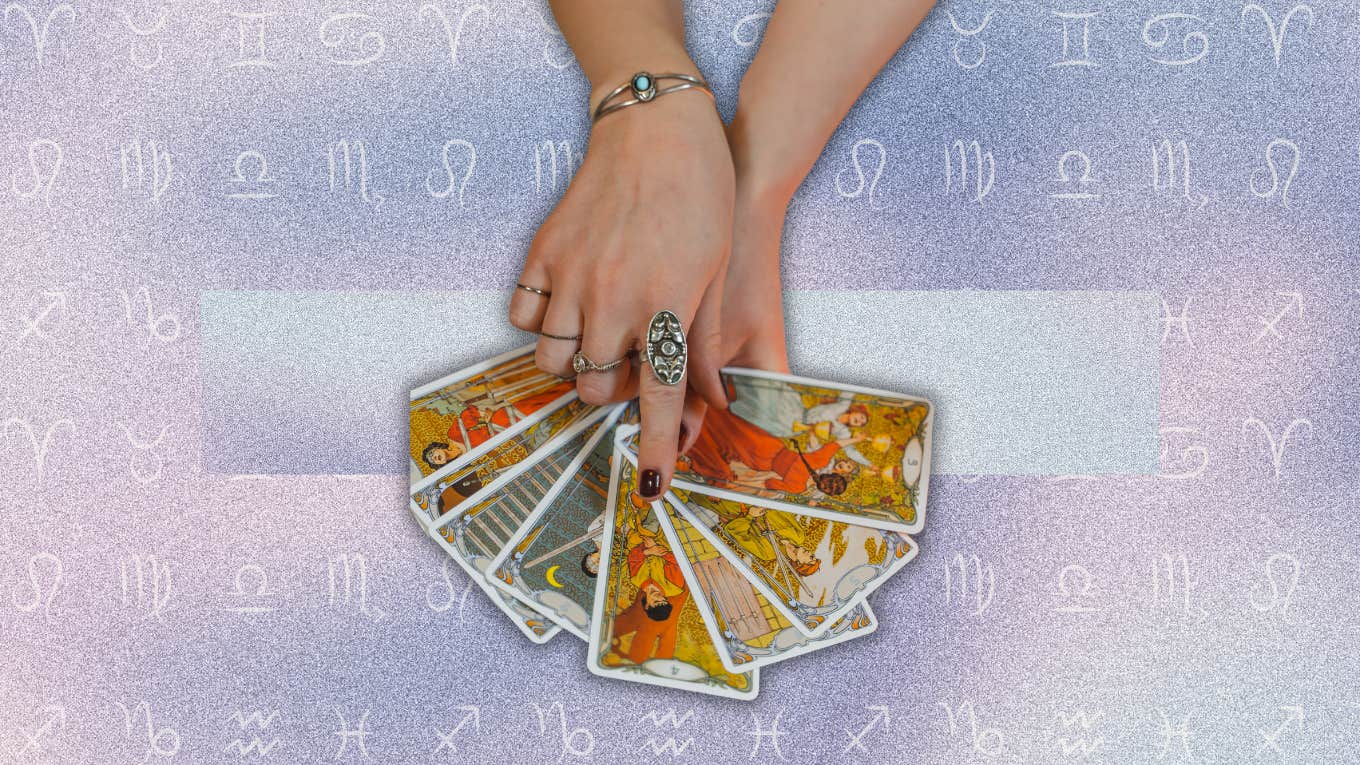 hand holding tarot card for horoscope may 31